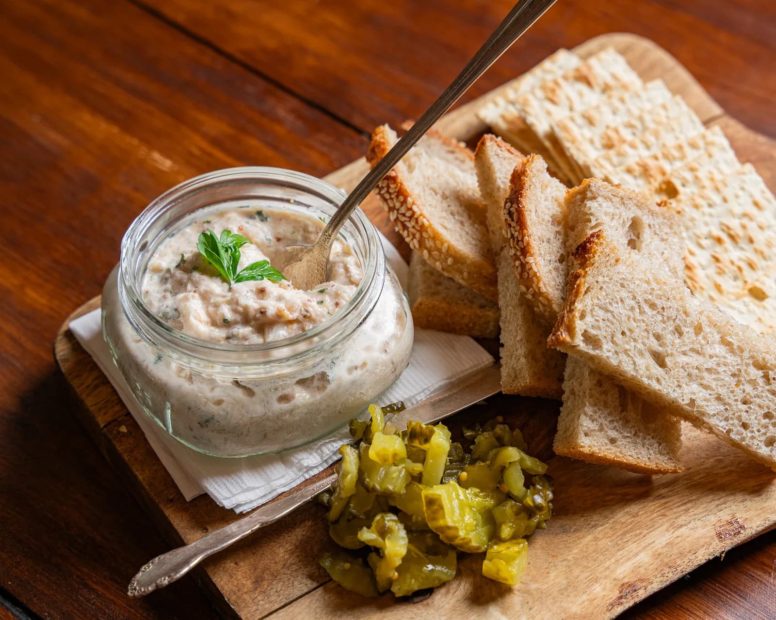 Smoked fish spread with bread, crackers and pickles.